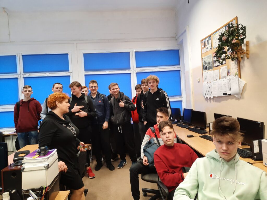 uczniowie słuchają, kobieta mówi w klasie