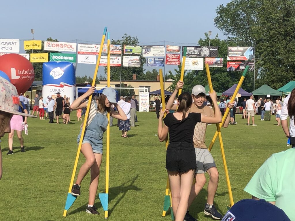 dzieci uczą sie chodzić na szczudłach