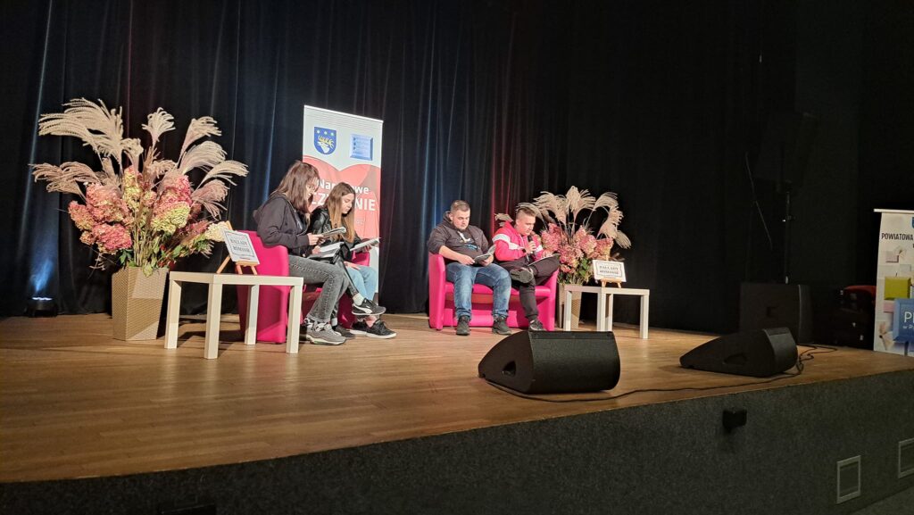 młodzież 4 osoby czytają na scenie