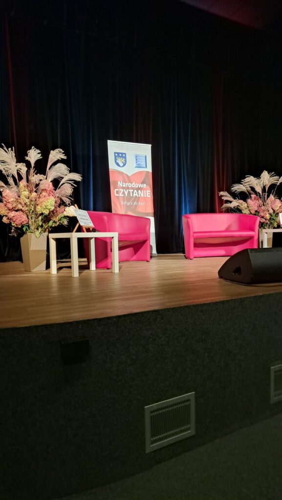 Narodowe czytanie, 2 czerwone fotele, 2 stoliczki, 2 bukiety i banner