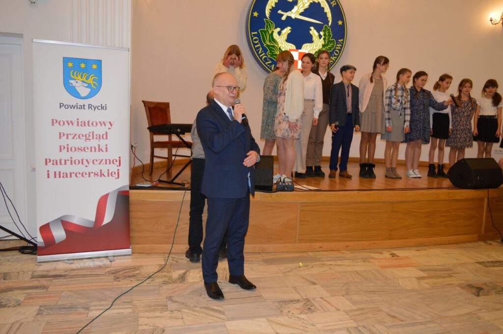Przegląd Piosenki Patriotycznej i Harcersskij Powiatowej Biblioteki Publicznej w Rykach, scena, przemówienie starosty