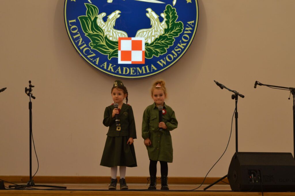 Przegląd Piosenki Patriotycznej i Harcersskij Powiatowej Biblioteki Publicznej w Rykach, scena, dwoje dzieci śpiewa
