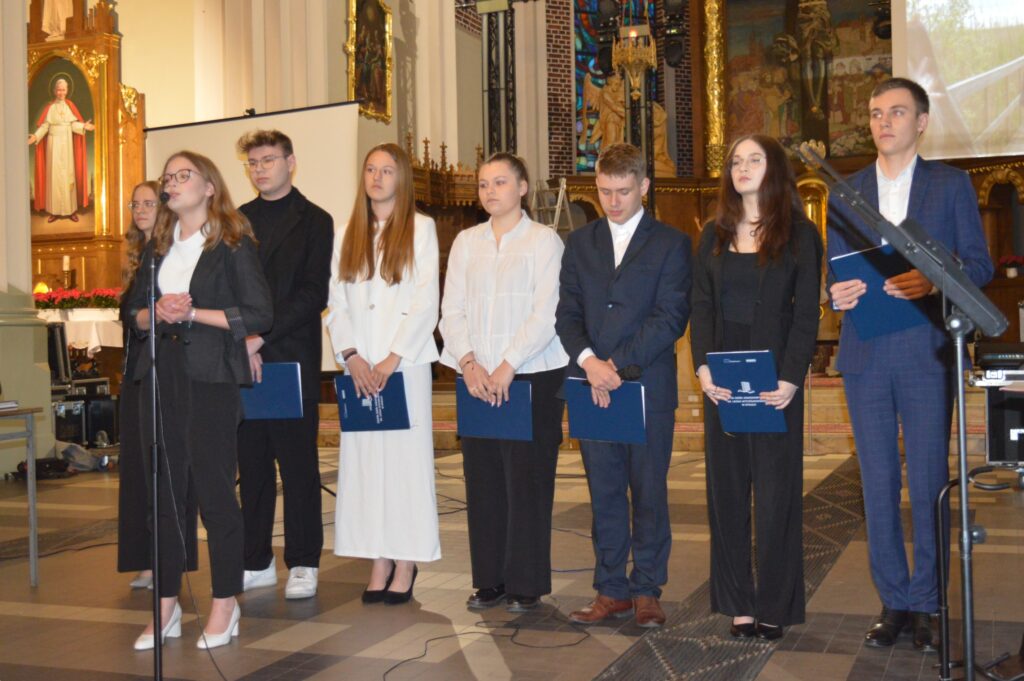 w Kościele stoją nagrodzeni uczestnicy konkursu na najciekawsze wykonanie montażu słowno-muzycznego poświęconego pamięci świętemu Jana Pawła drugiego