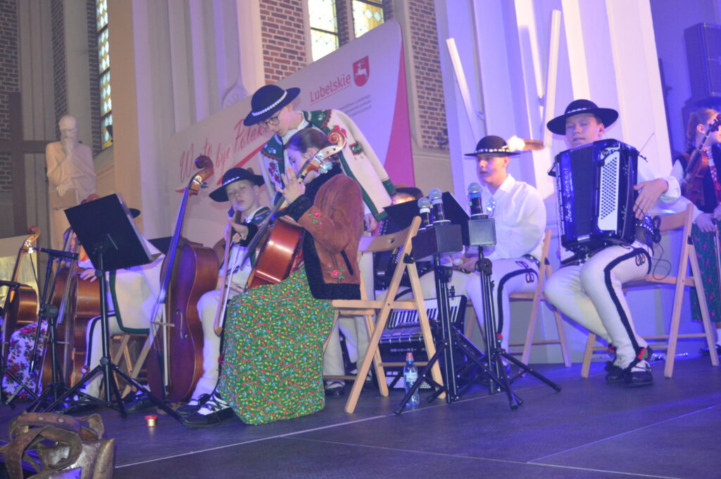 skrzypek w świetle reflektorów dyryguje zespołowi Mała Armia Janosika