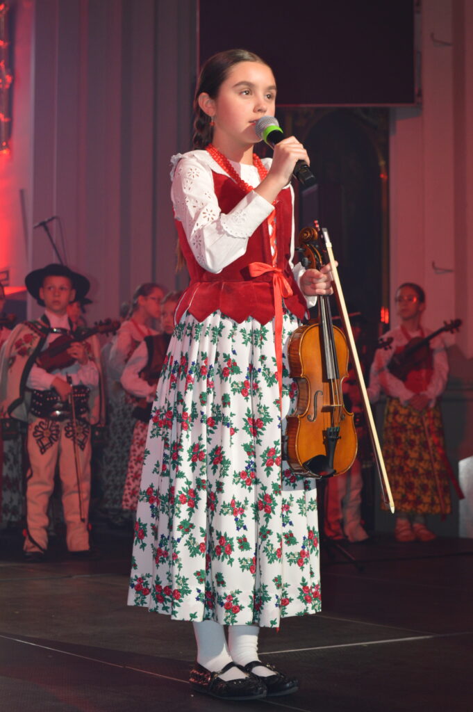 mała góralka śpiewa i trzyma skrzypce