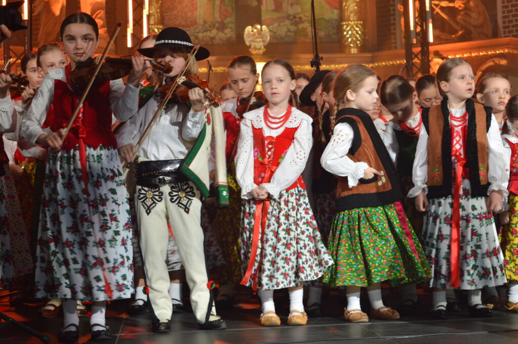 skrzypek w świetle reflektorów dyryguje zespołowi Mała Armia Janosika