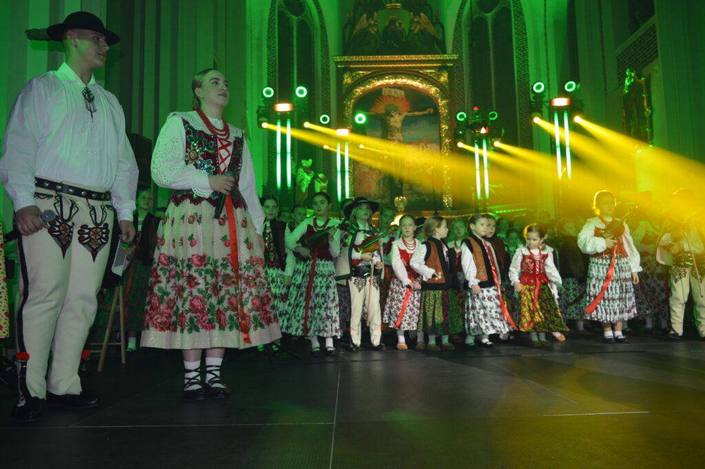 skrzypek w świetle reflektorów dyryguje zespołowi Mała Armia Janosika