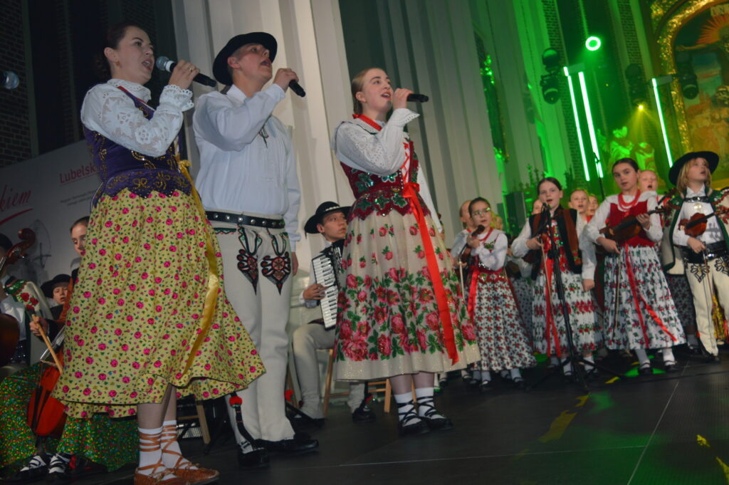 skrzypek w świetle reflektorów dyryguje zespołowi Mała Armia Janosika