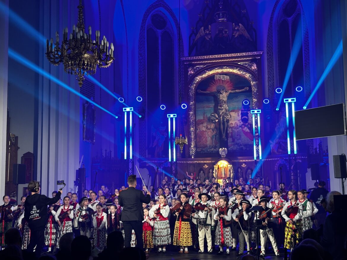skrzypek w świetle reflektorów dyryguje zespołowi Mała Armia Janosika
