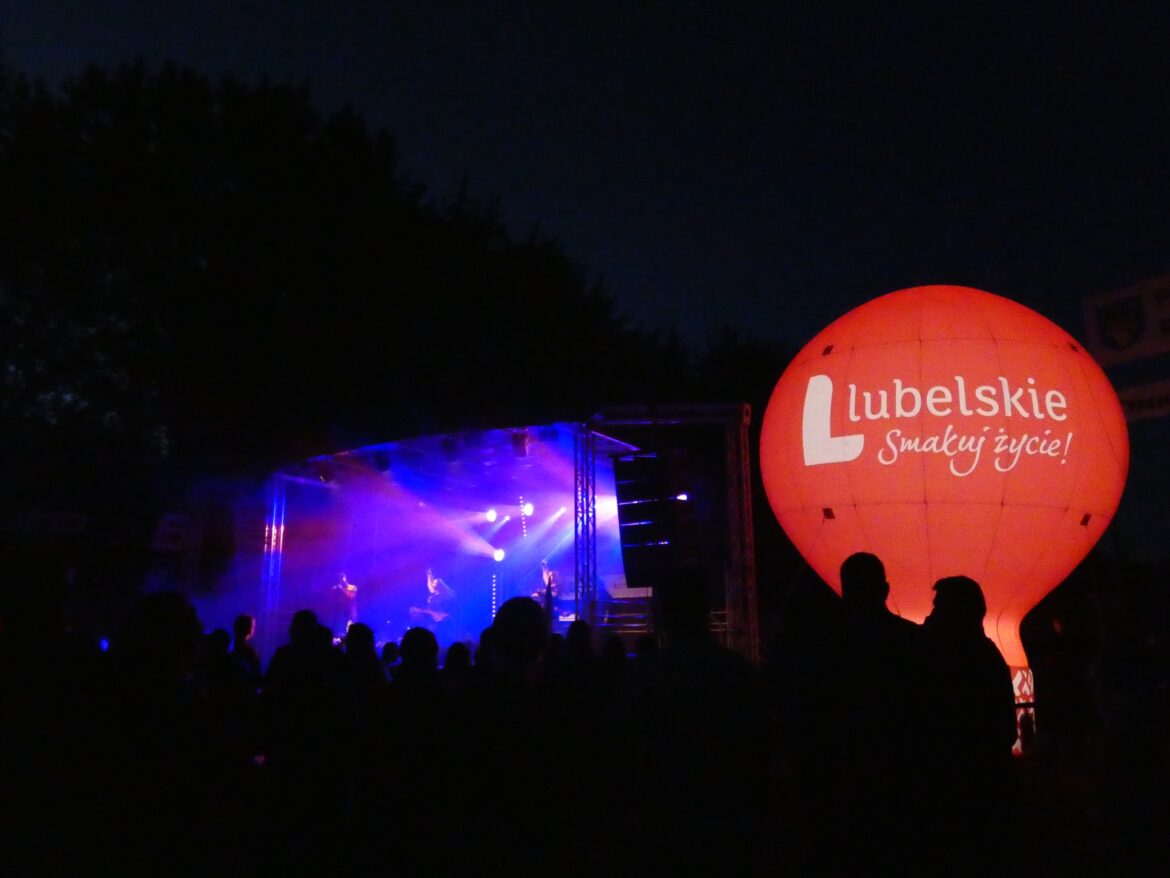 Czwrwony balon po prawj podświetlony- Lubelskie smakuj życie, jest noc i niebieskie światła po lewej