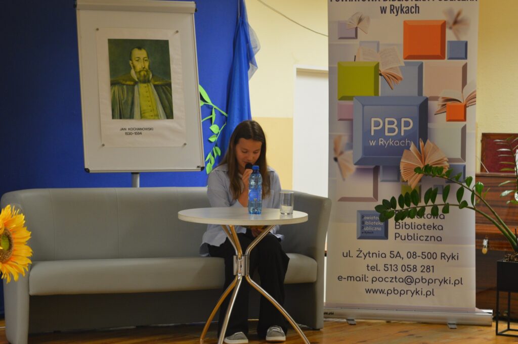 Czyta dziewczyna, siedzi, z boku żółte słoneczniki, tło narodowe czytanie, scena