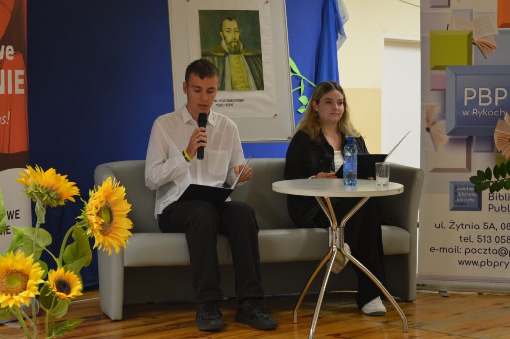 Czytają młodzieniec i dziewczyna, siedzą, z boku żółte słoneczniki, tło narodowe czytanie, scena