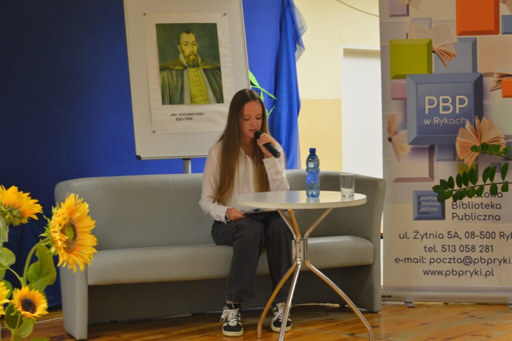 Czyta dziewczyna, siedzi, z boku żółte słoneczniki, tło narodowe czytanie, scena