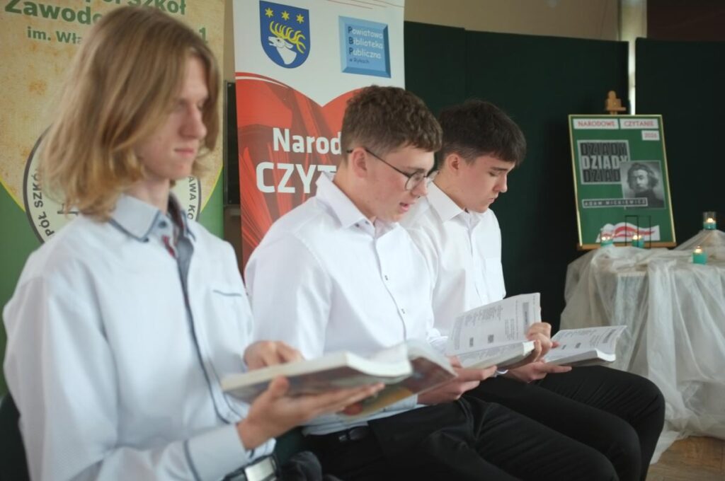 zdjęcie na tle dekoracji narodowe czytanie 2026 - czytają 3 osoby